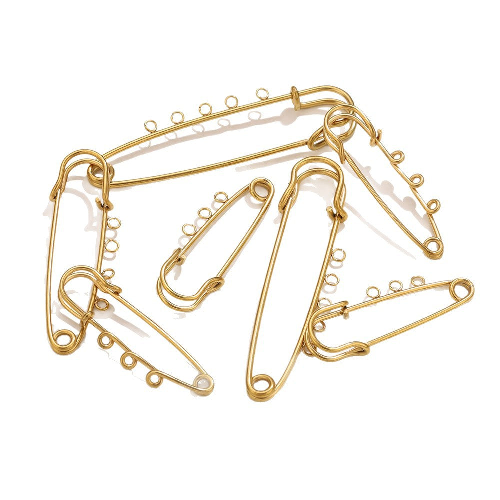 A set of gold-colored metal safety pins arranged on a plain white background.