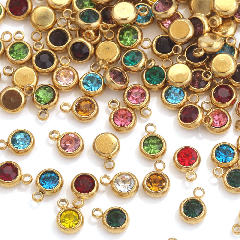 Gold-plated round crystal birthstone charms in assorted colors on white