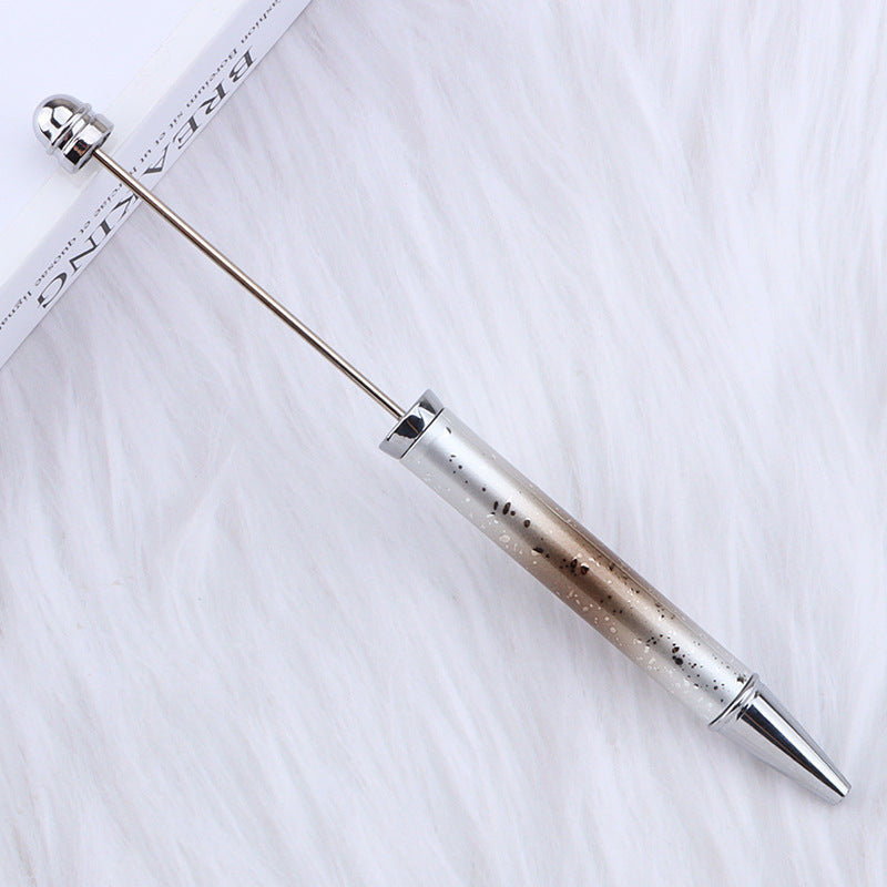 Metallic ombre beadable pen on a textured white surface.