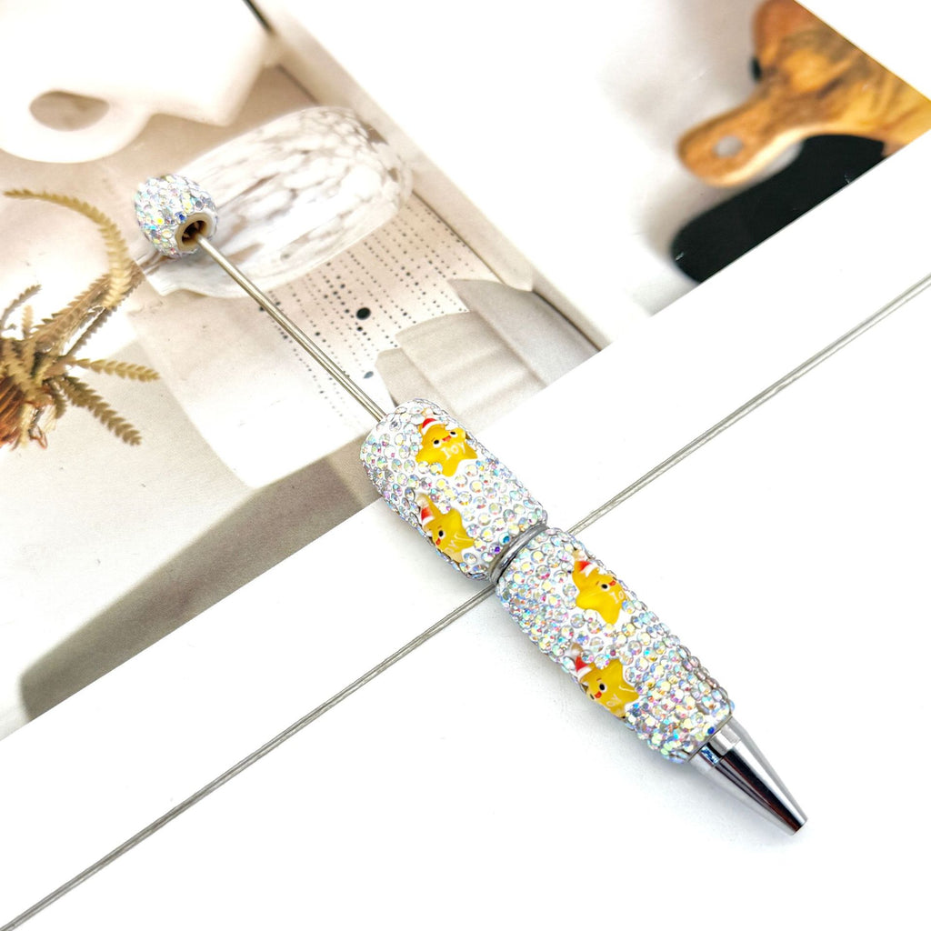 Silver ballpoint pen with clear rhinestones and yellow cartoon duck design.