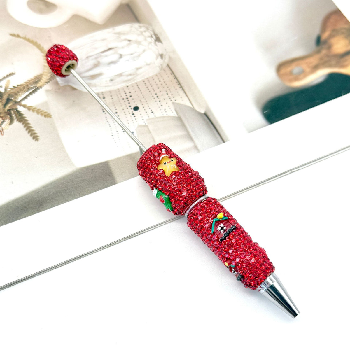 Red rhinestone-covered pen with matching cap and silver metal tip.