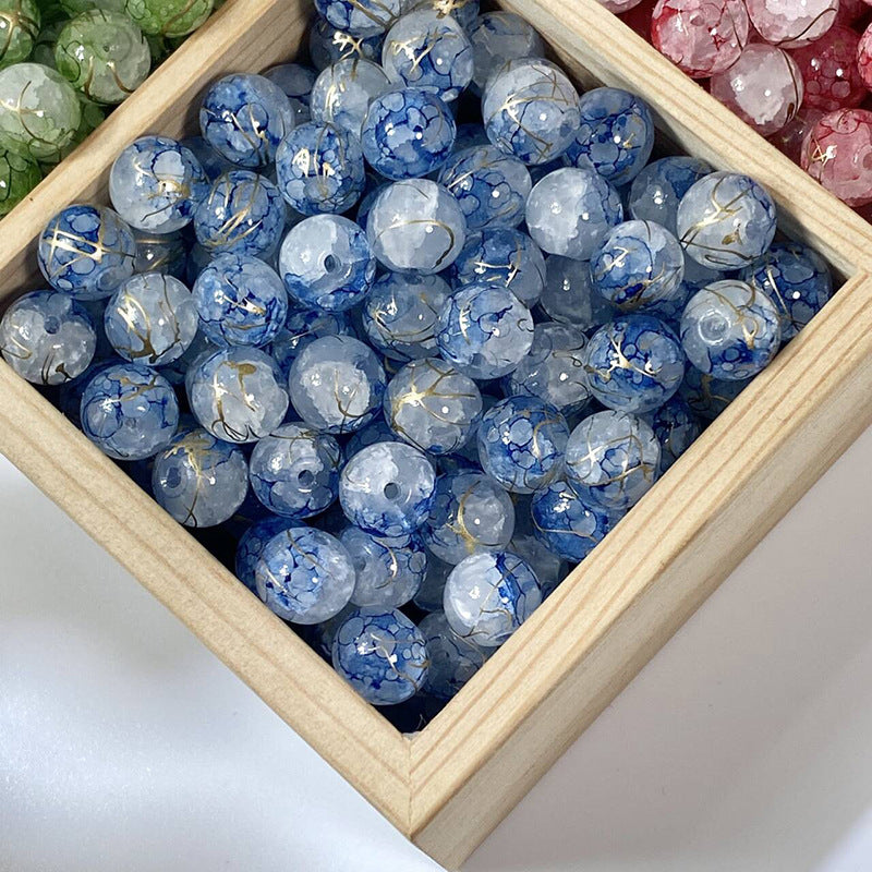 Blue crackle glass beads with gold-silk veins in a wooden tray