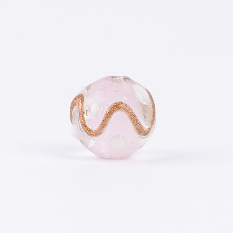 Single pink gold-sand swirl glass bead with gold line and white dots