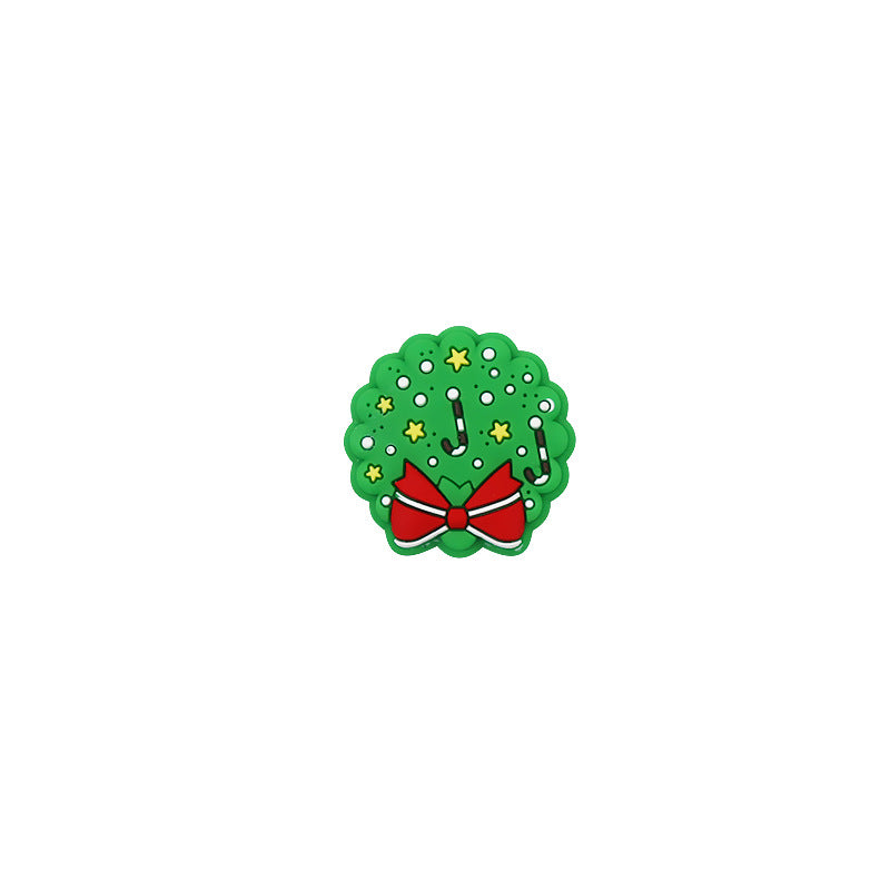 Green Christmas wreath silicone focal bead with red bow, yellow stars, and candy canes on white.