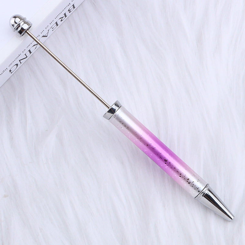 Pink and silver ombre beadable pen on a white fabric background.