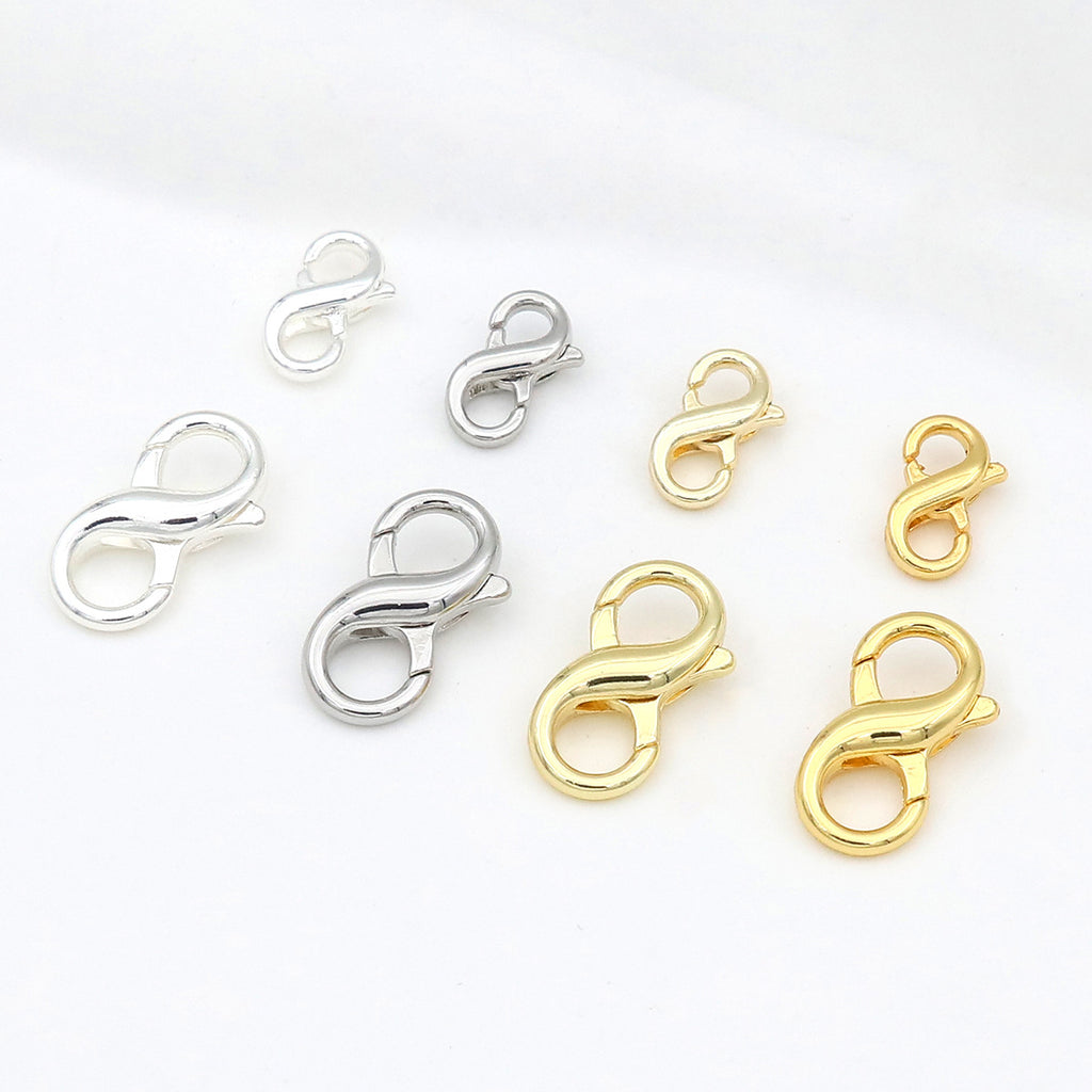 Six figure-eight lobster clasps in polished silver and gold finishes arranged on a white background