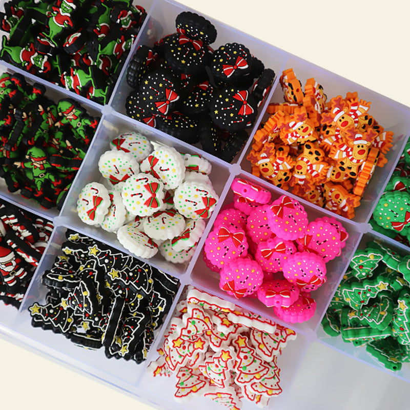 Compartmentalized tray of assorted Christmas silicone focal beads in red, green, black, white, pink, and orange.