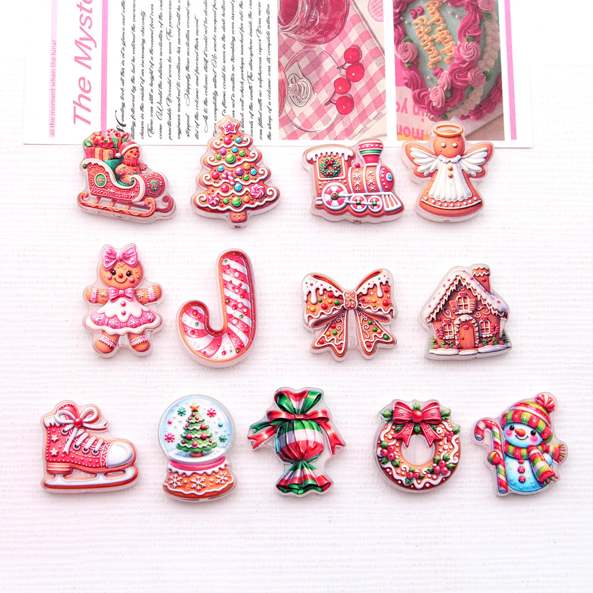 Set of 12 colorful Christmas-themed acrylic charms on white textured background