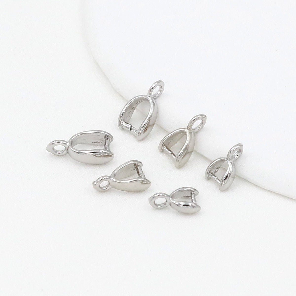 Silver pinch bail pendant clasps on a white background