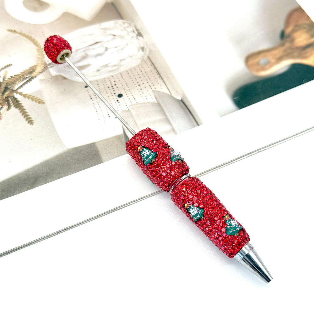 Red rhinestone ballpoint pen with green and white crystal holiday motifs.