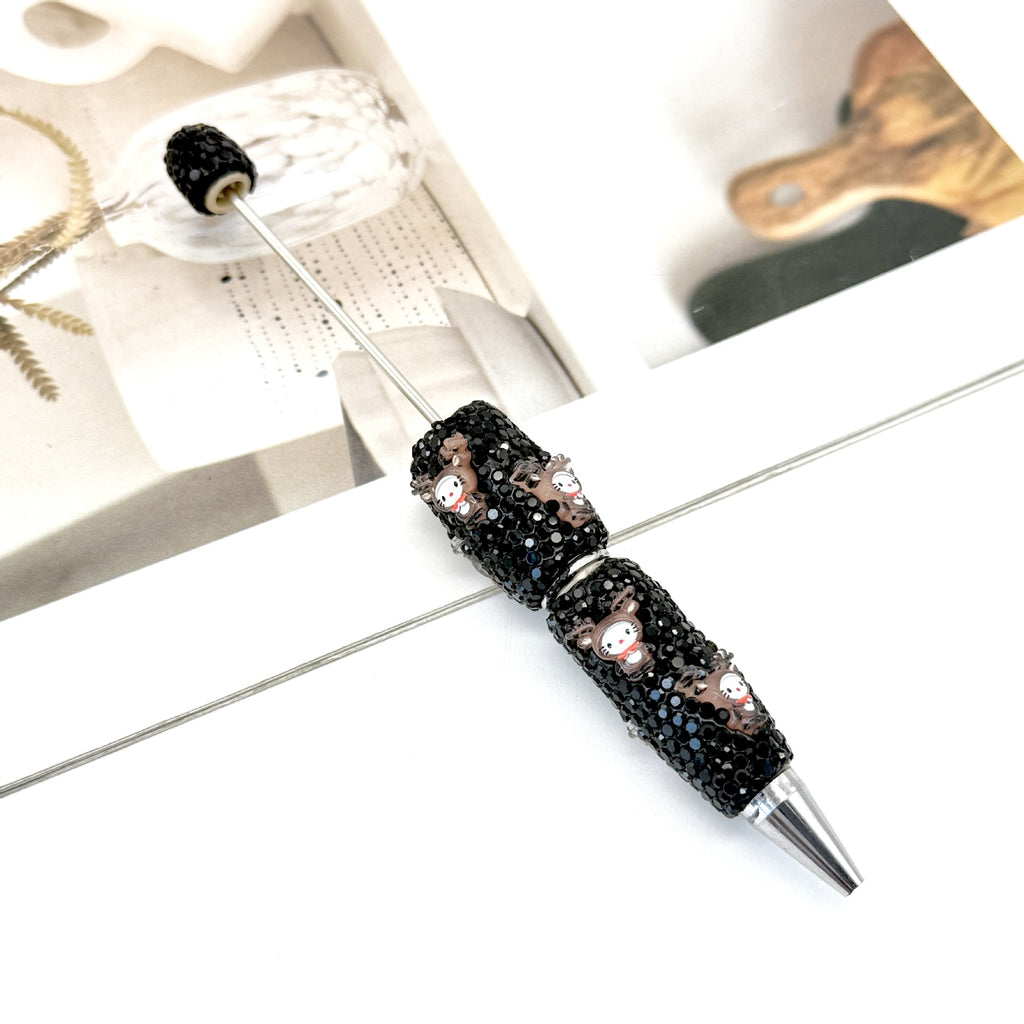 Black rhinestone ballpoint pen with small cartoon owl charms.