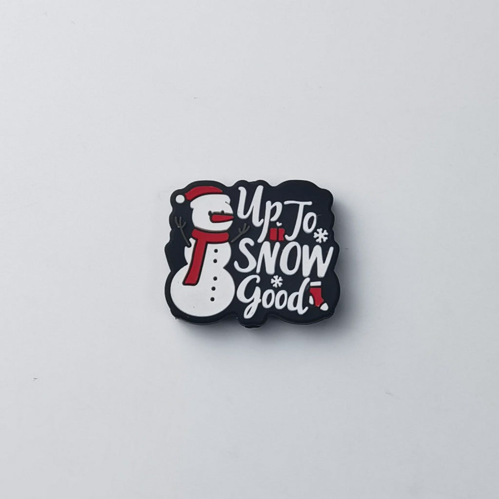 Black silicone focal bead shaped like a snowman with white 'Up to Snow Good!' lettering