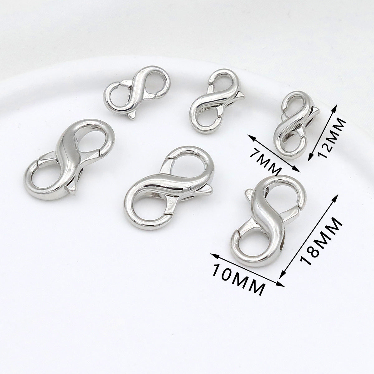 Six silver figure-eight lobster clasps in different sizes on white with dimension labels showing 7mm, 10mm, 12mm, and 18mm