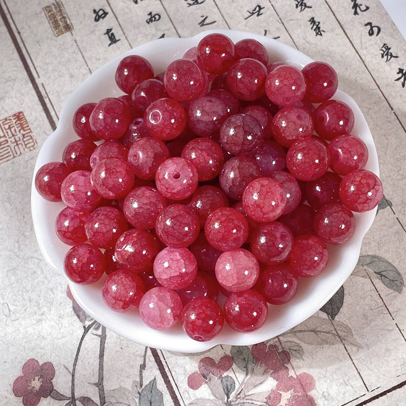 Red 10mm water-dyed jade-style crackle glass beads in a white bowl