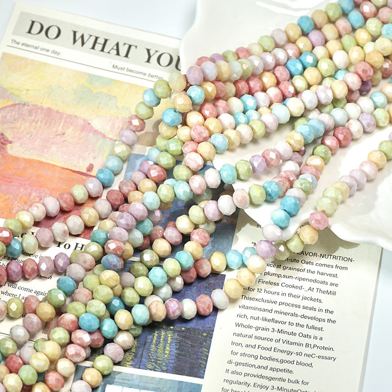 Loose strands of pastel marbled porcelain beads over an open printed book