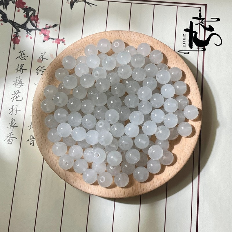 White translucent round beads in a wooden bowl with Chinese characters background