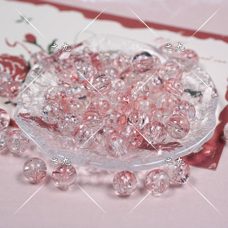 Clear round beads with pink glitter in a glass dish on a pale pink surface