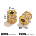 Two gold-toned cylindrical spacer beads with clear rhinestone-like accents, shown on a white background with dimension labels reading 10mm width and 10mm height, plus a hole size of 4mm. Text at the bottom mentions stainless steels and weight.
