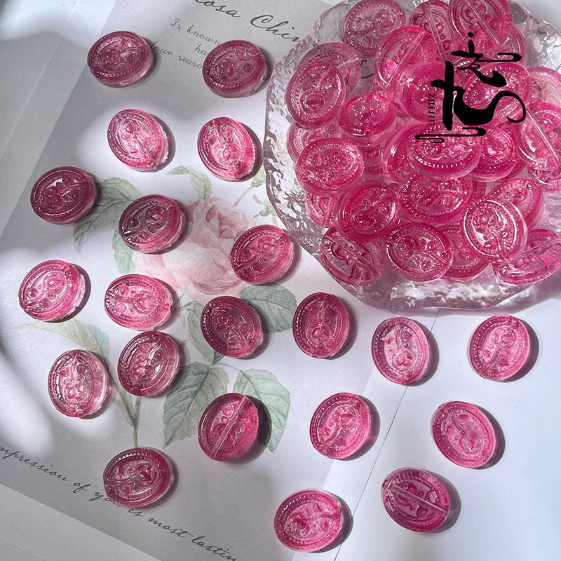 Pink translucent engraved glass rose beads scattered on white floral paper
