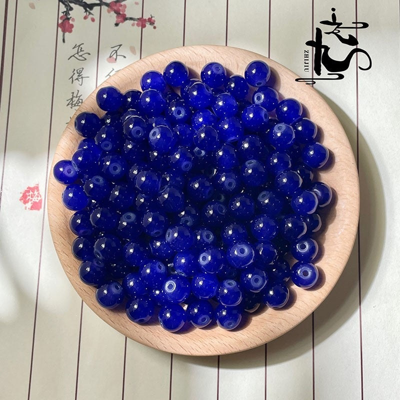 Deep blue translucent round beads on a wooden plate with calligraphy background