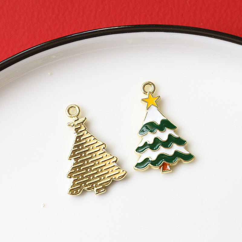 Two Christmas tree charms on white plate with red background, gold textured