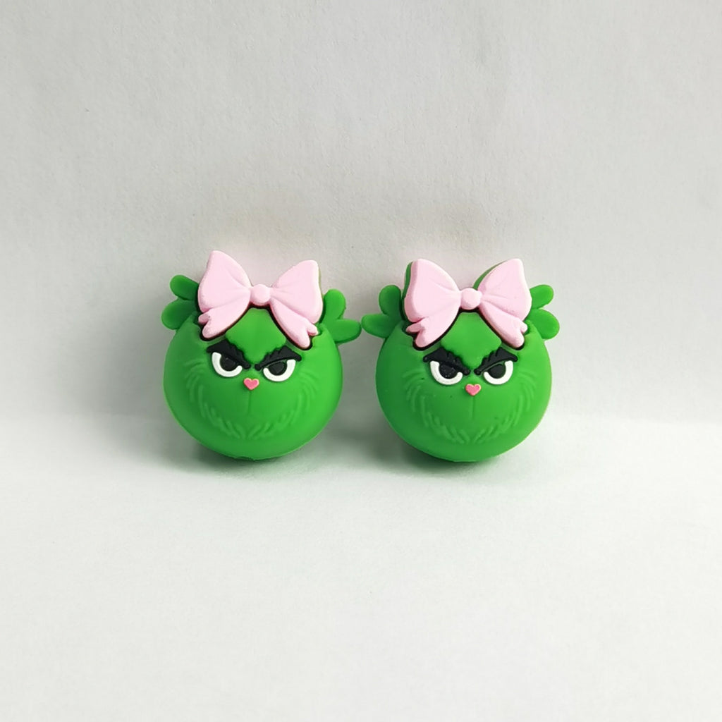 Pair of green Grinch-like silicone focal beads with angry eyes and pink bows
