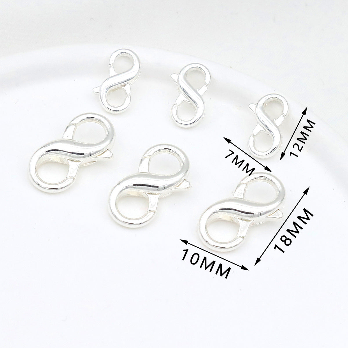 Five silver figure-eight lobster clasps in different sizes on white with dimension labels showing 7mm, 10mm, 12mm, and 18mm
