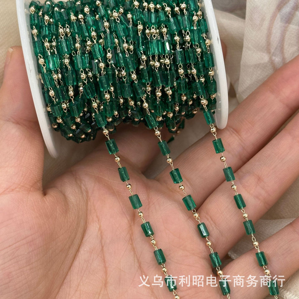 A close-up of a hand holding a spool of green faceted glass beads with small gold spacer beads, with several strands draped over the palm. Chinese text is visible at the bottom.