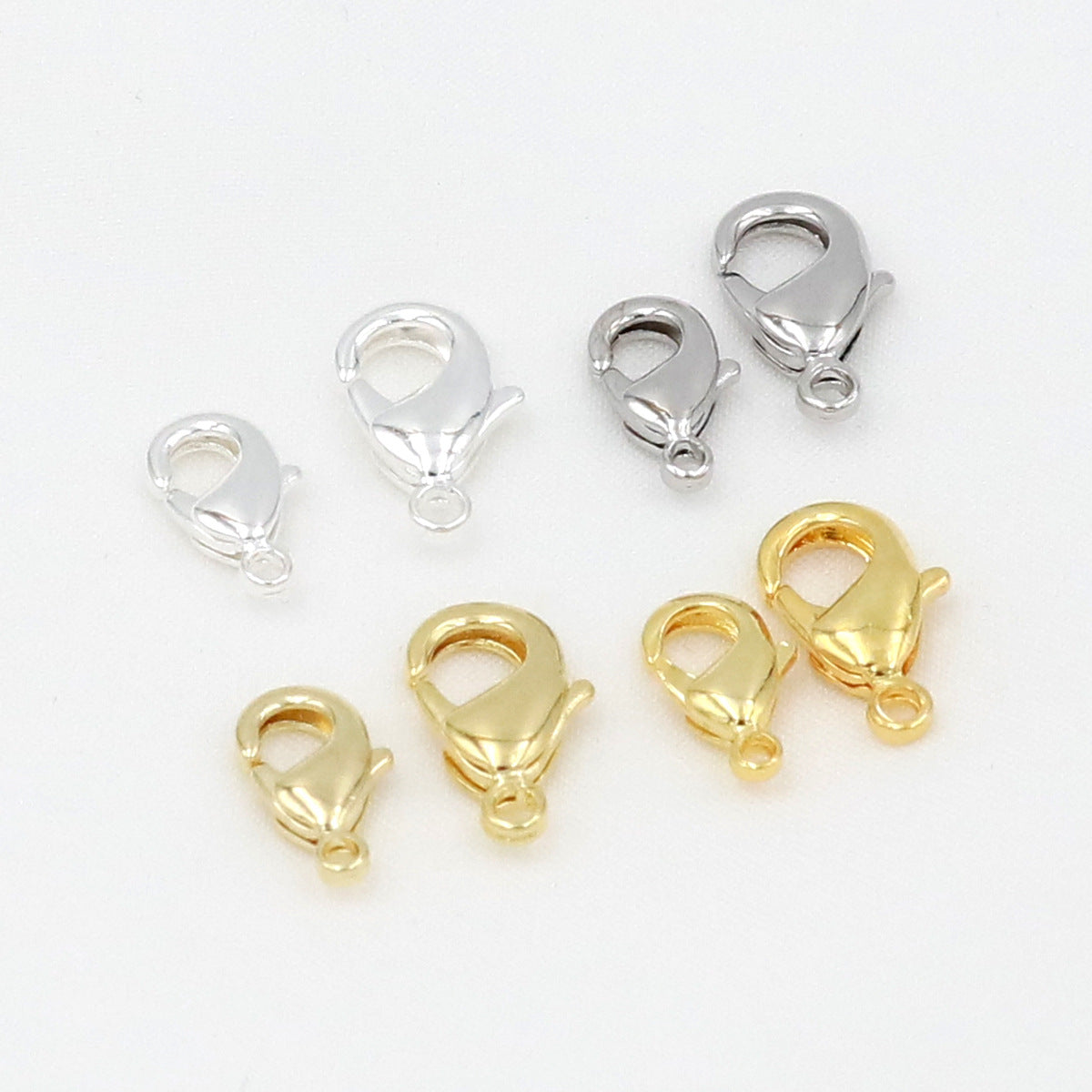 Gold and silver teardrop lobster clasps in assorted sizes on white background