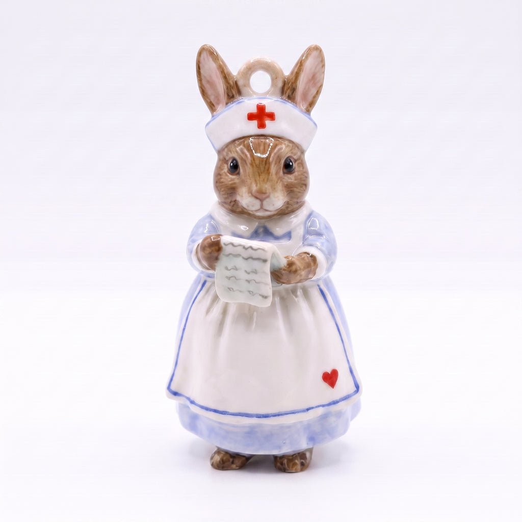 3D rabbit pendant charm dressed as nurse, holding paper sheet, wearing white dress.
