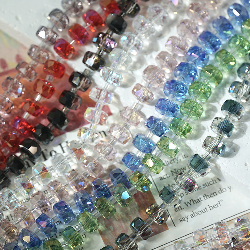 Strands of faceted crystal wheel beads in assorted colors arranged diagonally on a light surface with printed text