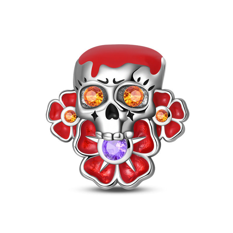 Silver-plated skull bead with red enamel, orange crystal eyes, red flower sides, and purple heart crystal