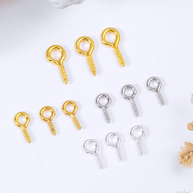 Nine small screw eye pins in gold and silver finishes on a white background