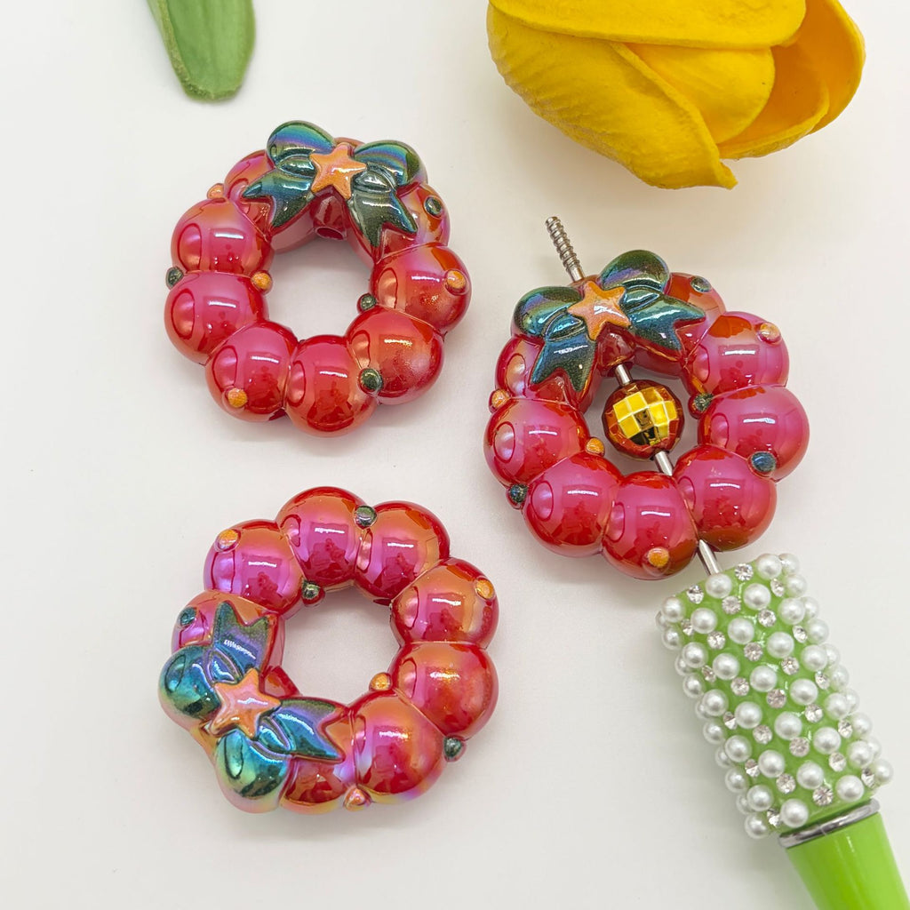 Three pink and red berry-patterned wreath acrylic focal beads with green leaves