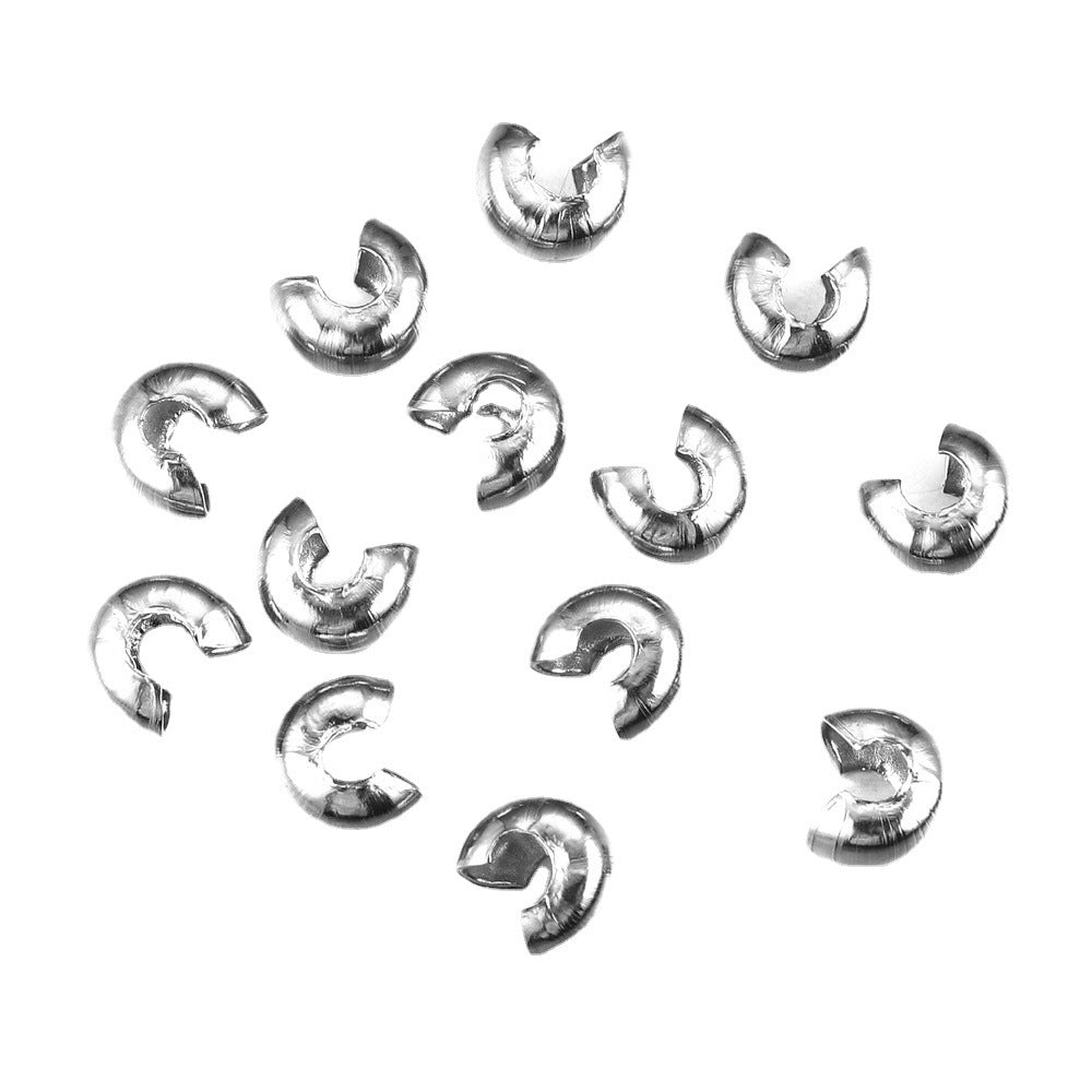 Twelve silver C-shaped crimp bead covers scattered on a white background.