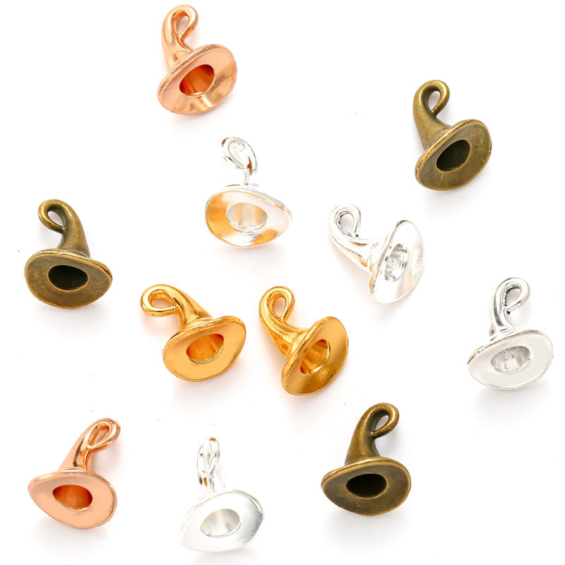 Ten small metal jewelry findings or charm components in assorted finishes, including gold, rose gold, bronze, and silver, arranged on a plain white background.