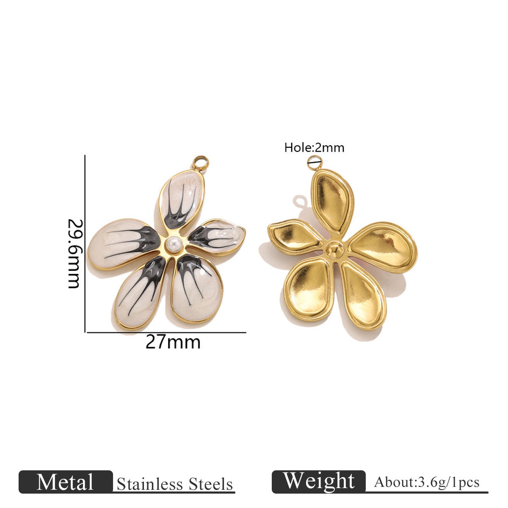 Two gold-toned flower pendant charms, one with black and white enamel petals and pearl center, 29.6mm by 27mm
