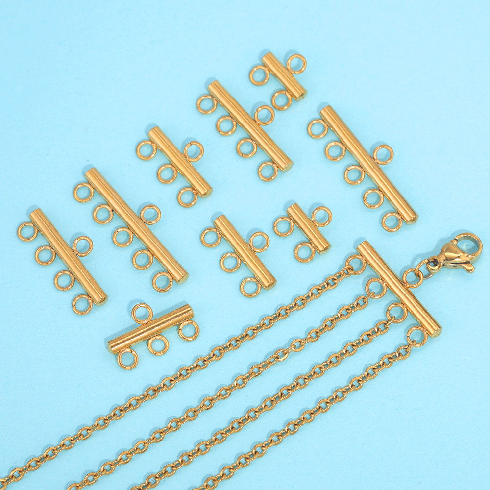 Gold-toned stainless steel multi-loop connector bars with chains on light blue background