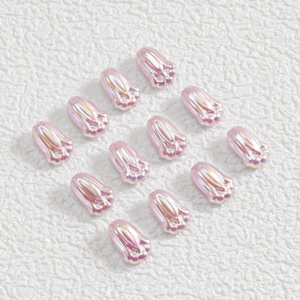 Twelve small iridescent pink flower-shaped beads in a loose diagonal grid on white