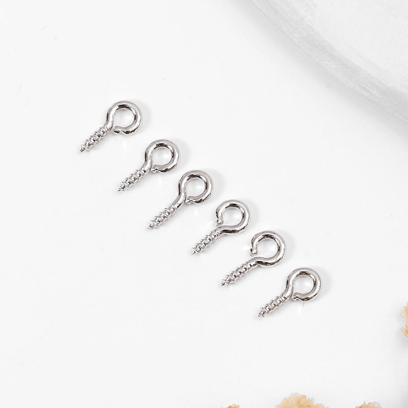 Five silver metal screw eye pins arranged diagonally on a white background