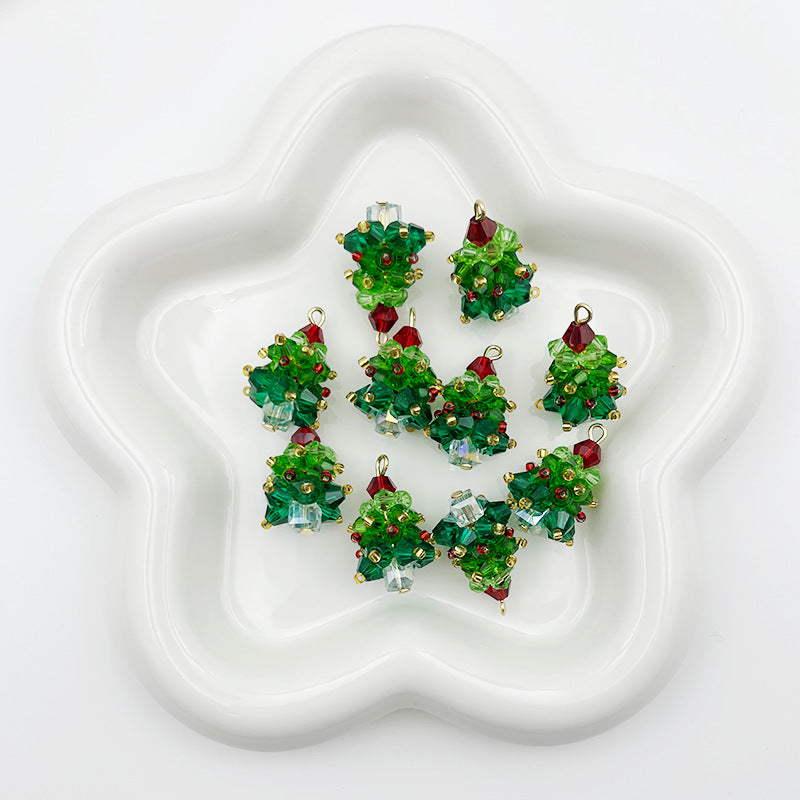 Six small Christmas tree-shaped charms with green faceted crystals and gold-tone metal outlines