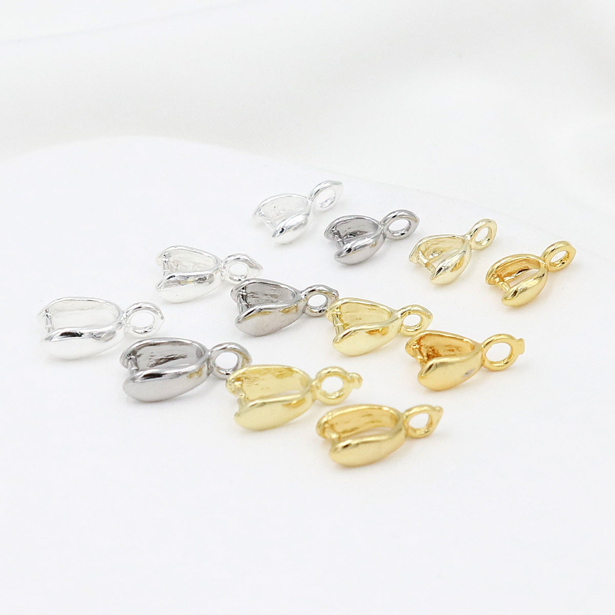 Gold-plated pinch bail pendant clasps in polished silver and gold finishes on a white background