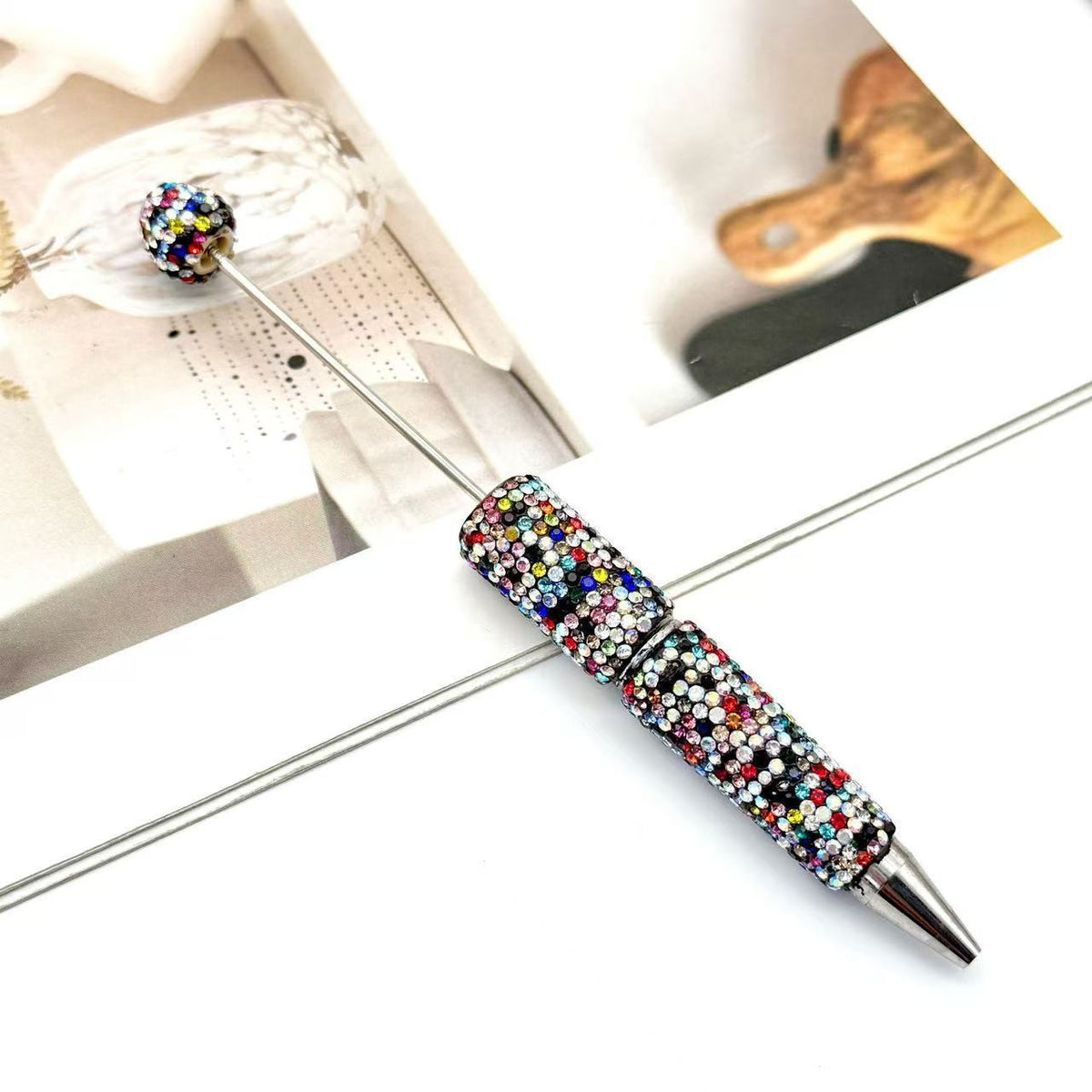 Silver metal ballpoint pen decorated with dense multicolor rhinestones and a matching rhinestone top
