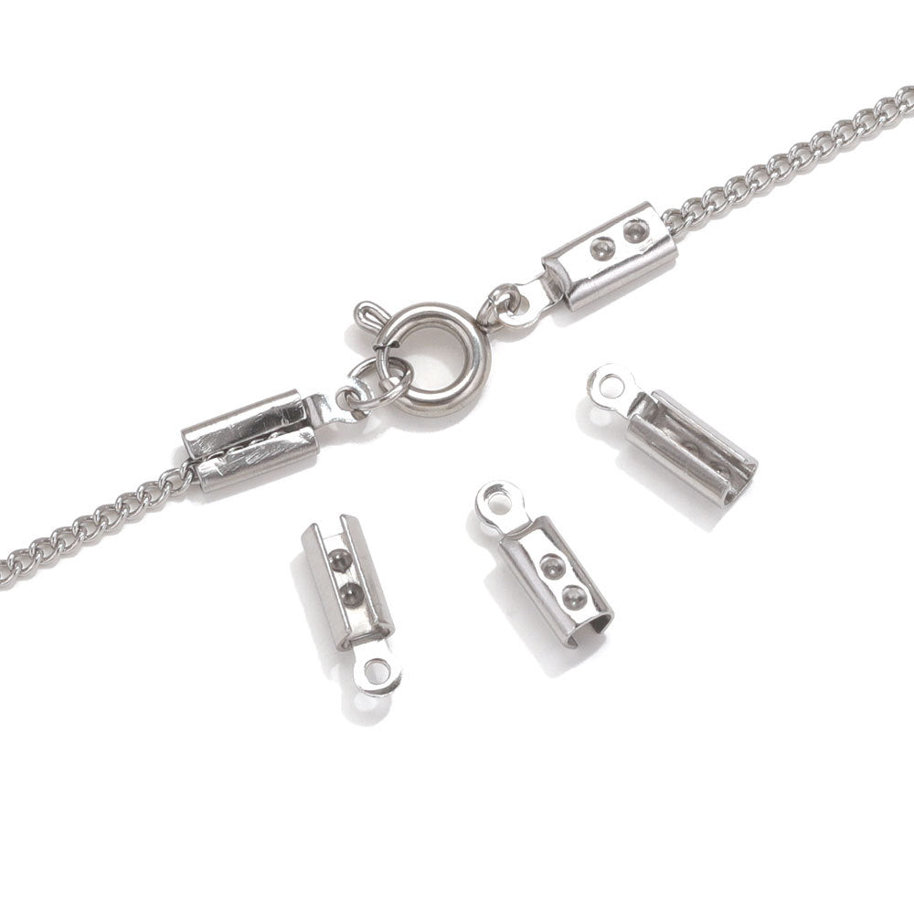Silver chain necklace with barrel cord-end connectors and lobster clasp on white, four loose connectors below