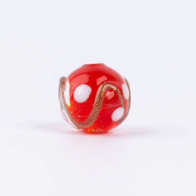 Single red gold-sand swirl glass bead with white polka dots and gold glitter
