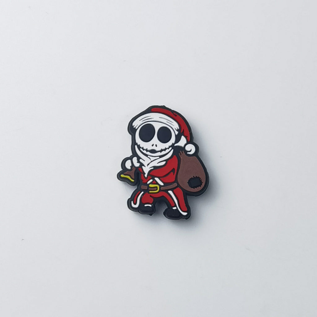 Silicone focal bead shaped like a cartoon skeleton dressed as Santa Claus carrying a brown sack