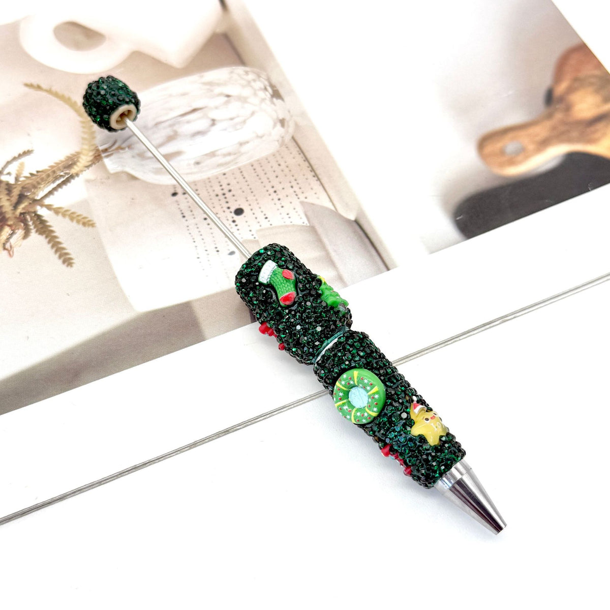 Dark green rhinestone ballpoint pen with Christmas-themed embellishments.