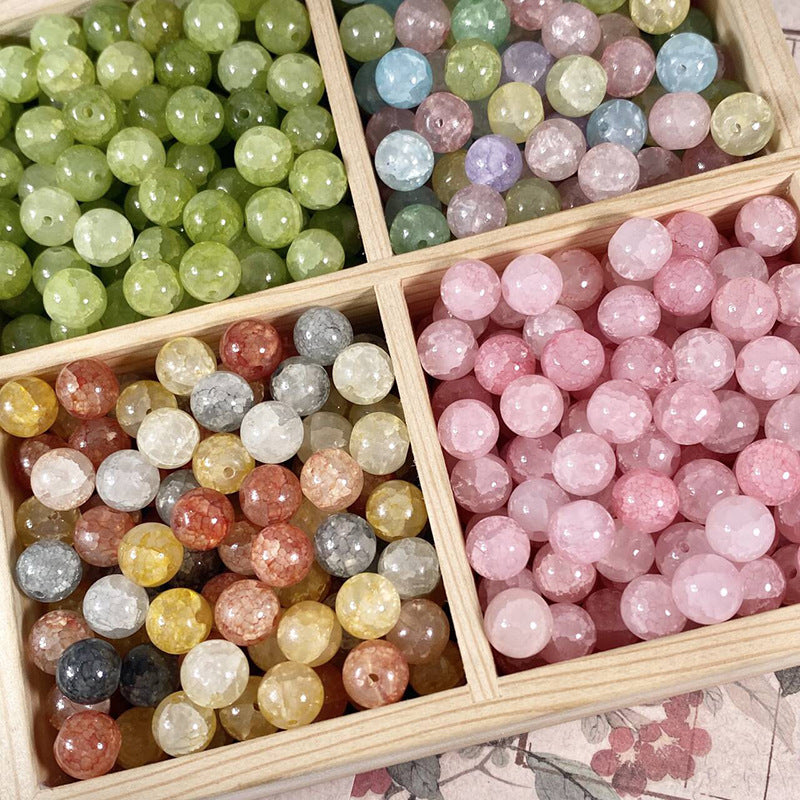 Faceted round beads in multiple colors arranged in a wooden divided tray