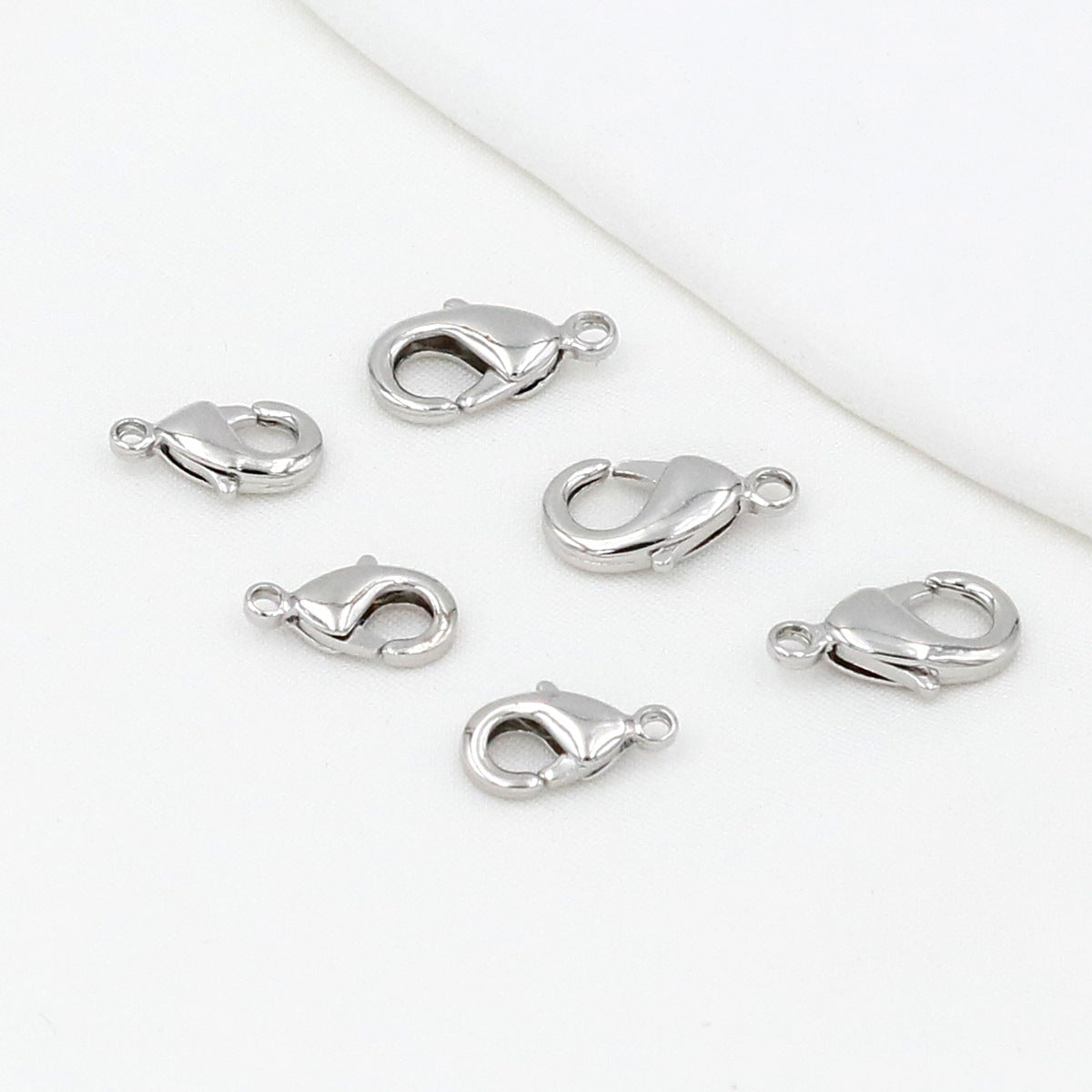 Silver teardrop lobster clasps on a white background