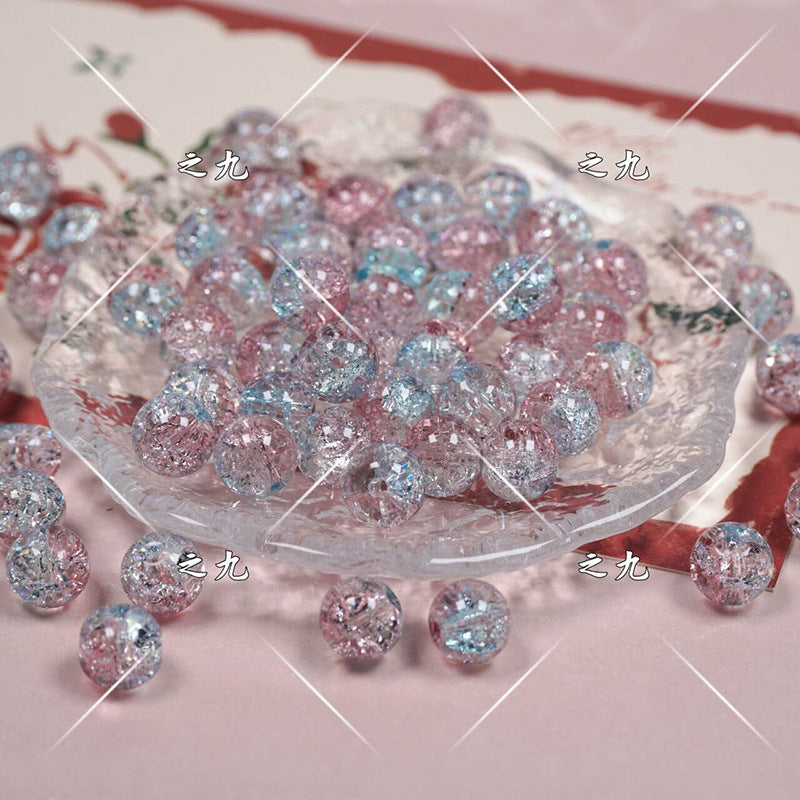 Pink and light blue glittery beads on a glass dish over a pink floral background